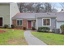 Charming townhouse featuring a well-manicured front yard and a welcoming red front door at 5840 Branchwood Rd, Raleigh, NC 27609
