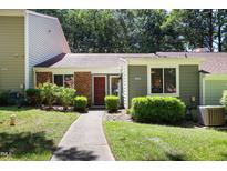 Charming single-story home featuring a brick facade, red door, and well-maintained landscaping at 5840 Branchwood Rd, Raleigh, NC 27609