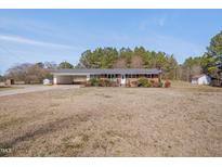 Charming one-story brick home featuring a spacious front yard and attached carport at 6605 Pearces Rd, Louisburg, NC 27549