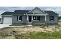 Charming single-story home features a gray exterior, stone accents, and a cozy front porch at 82 Asher Pointe Way, Benson, NC 27504