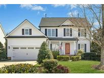 Charming two-story traditional home featuring an attached garage, landscaped yard, and a welcoming front porch at 1002 Augustine Trl, Cary, NC 27518