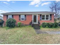 Charming brick home with well-maintained front yard and classic architectural details, offering a welcoming curb appeal at 1004 Carlisle St, Raleigh, NC 27610