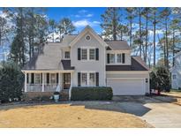 Charming two-story home with a well-manicured lawn, inviting front porch, and attached two-car garage at 104 E Seve Ct, Morrisville, NC 27560