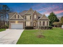 Charming two-story home featuring a manicured lawn, attached two-car garage, and stone and siding details at 109 Coffeeberry Ct, Garner, NC 27529