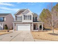 Charming two-story home featuring a well-manicured lawn, inviting front porch, and attached two-car garage at 127 Lakemont Dr, Clayton, NC 27520