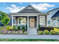 Charming home featuring inviting front porch, stylish landscaping and craftsman design details at 135 Village Walk Dr, Clayton, NC 27527