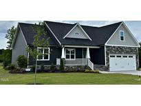 Charming single Gathering home with a white garage door, lovely front porch, and well-manicured front lawn at 143 Prency Ln, Middlesex, NC 27557