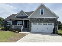 Charming home featuring a two-car garage, stone accents, and well-manicured lawn at 143 Prency Ln, Middlesex, NC 27557