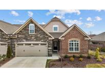 Charming home featuring stone and brick accents, a two-car garage, and a beautifully landscaped front yard at 170 Dunvegan Ln, Burlington, NC 27215