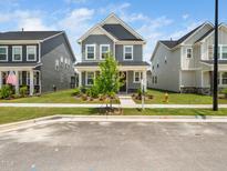 Charming two-story home with gray siding, a landscaped yard, and a welcoming front porch at 1981 Rosedale Ridge Ave, Wake Forest, NC 27587