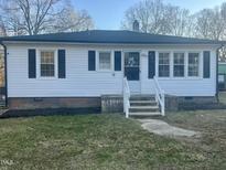 Charming one-story home featuring white siding, black shutters, and well-maintained landscaping at 202 Harper Rd, Hillsborough, NC 27278