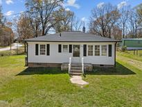 Charming single-story home with a white exterior, dark shutters, and a well-maintained lawn at 202 Harper Rd, Hillsborough, NC 27278