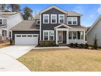 Charming two-story home features a covered front porch and a two-car garage at 2609 Aster Ct, Apex, NC 27502