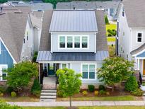 Charming two-story home features a metal roof, inviting front porch, and manicured landscaping at 5520 Advancing Ave, Raleigh, NC 27616
