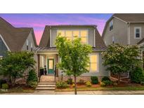 Charming two-story home with landscaped front yard, teal door, and inviting curb appeal at 5520 Advancing Ave, Raleigh, NC 27616