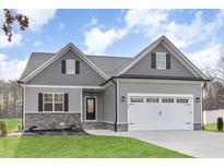 Charming gray home with a two-car garage, gray roof, and manicured lawn and professional landscaping at 60 Pintail Lane Ln, Youngsville, NC 27596