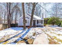 Charming single Gathering home with manicured lawn and walkway in winter at 6600 Ascot Ct, Raleigh, NC 27615