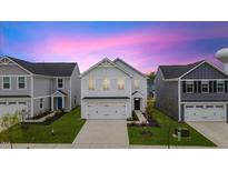 Beautiful two-story home with a two car garage and a well-manicured lawn at dusk at 669 Impala Trce, Wendell, NC 27591