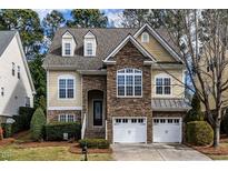 Charming two-story home featuring a stone facade, two-car garage, and manicured landscaping at 1028 Dotson Way, Apex, NC 27523