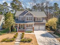 Charming two-story home featuring a covered porch, well-manicured lawn, and a two-car garage at 10312 River Bank Dr, Raleigh, NC 27614