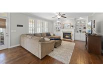 Comfortable living room featuring a fireplace, built-in shelving, and stylish decor at 109 Skywater Ln, Holly Springs, NC 27540
