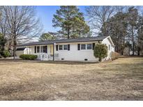 Charming white-brick ranch home with black shutters and a welcoming front porch, nestled in a wooded yard at 11254 Hwy Nc 50, Benson, NC 27504