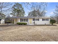 Charming white brick home featuring black shutters, carport, and a well-manicured lawn at 11254 Hwy Nc 50, Benson, NC 27504