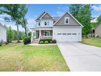 Charming two-story home with stone accents, a well-manicured lawn, and an attached two-car garage at 115 Lockamy Ln, Youngsville, NC 27596