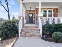 Charming front porch with stone steps and pillars, leading to a welcoming front door of the home at 115 Lockamy Ln, Youngsville, NC 27596