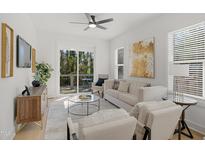 Bright living room with modern ceiling fan, stylish furniture, and sliding glass doors to a deck at 1410 Joe Louis Ave, Raleigh, NC 27610