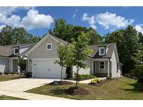 Charming home featuring a light-colored exterior, well-manicured lawn, and a two-car garage at 1413 Buxus Ct, Fuquay Varina, NC 27526