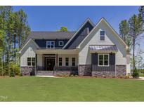 Charming two-story home featuring a manicured lawn and welcoming front porch at 15 Harvest View Way, Franklinton, NC 27525