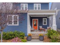 Charming blue house featuring an inviting front porch with an orange door and porch swing, perfect for relaxing outdoors at 1520 Rhodeschool Dr, Wendell, NC 27591