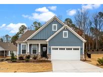 Beautiful two-story home with blue siding, a well-manicured lawn, and a two-car garage at 1609 Stonemill Falls Dr, Wake Forest, NC 27587