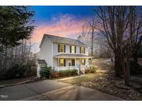 Charming two-story home with a welcoming front porch and neutral siding at 220 Hocutt Dr, Clayton, NC 27520