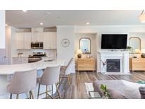 Stylish living room with modern kitchen, fireplace, and elegant decor, perfect for comfortable living and entertaining at 2929 Great Lawn Rd, Apex, NC 27502