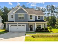 Charming two-story home with a manicured lawn, attached two car garage, and beautiful curb appeal at 340 Olde Liberty Dr, Youngsville, NC 27596