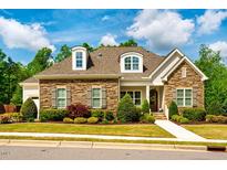 Charming, stone-accented home features dormer windows, manicured landscaping, and a welcoming entrance at 44 Ashwood Dr, Chapel Hill, NC 27516