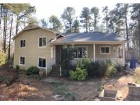 Charming two-story home featuring a cozy covered porch and mature trees at 4401 Sprague Rd, Raleigh, NC 27613