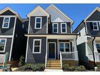 Charming two-story home with a modern exterior, inviting front porch, and freshly landscaped yard at 502 Yeowell Dr, Chapel Hill, NC 27514