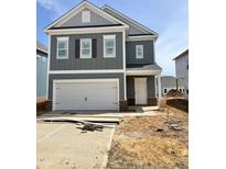 Two-story gray house with a white garage door, complemented by brick accents at the base at 52 Commons Cir, Clayton, NC 27520