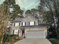 Charming two-story home with a gray exterior, blue shutters, red front door and a well-manicured lawn at 6 Hurdle Ct, Durham, NC 27713