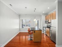 Bright kitchen featuring stainless steel appliances, hardwood floors, and a granite-topped island with seating at 610 Hillsborough St # 304, Raleigh, NC 27603