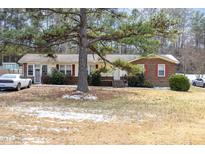Charming single-story home featuring a brick facade and a well-maintained front yard with mature trees at 722 Forge Rd, Durham, NC 27713