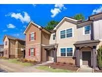 Charming townhome exteriors showcasing brick accents, varied siding, and inviting front entrances with manicured landscaping at 736 Wickham Ridge Rd, Apex, NC 27539