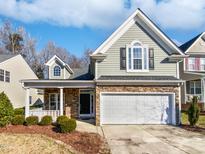 Charming two-story home features a stone facade and a two-car garage at 8209 Rolling Glenn Dr, Raleigh, NC 27616