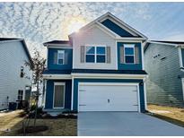 Charming two-story home with blue siding, a two-car garage, and manicured lawn at 83 Commons Cir # 236, Clayton, NC 27520