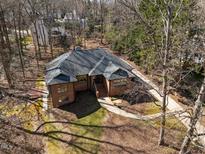 Stunning aerial view of a brick home with a manicured lawn and mature trees on a sunny day at 8804 Ross Ct, Raleigh, NC 27613