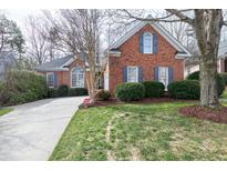 Charming brick home featuring a well-manicured lawn, classic shutters, and a welcoming driveway at 1205 Wedgeland Dr, Raleigh, NC 27615