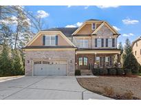 Charming brick two-story home featuring a spacious two-car garage and inviting front porch at 1881 Edith Dr, Raleigh, NC 27612
